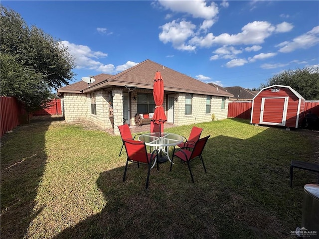 back of house featuring a yard and a storage shed