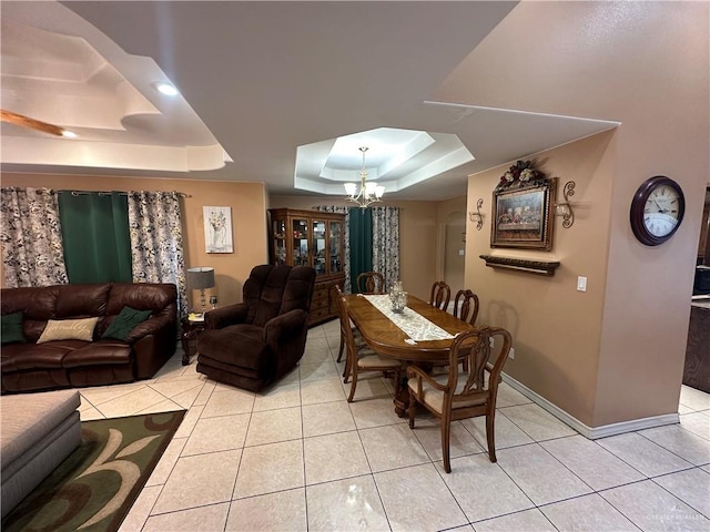 dining space featuring a raised ceiling, light tile patterned floors, and an inviting chandelier