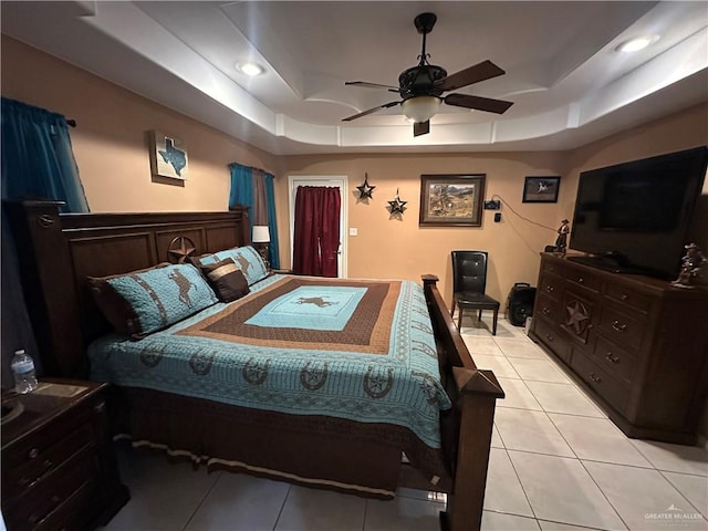 bedroom with a tray ceiling, ceiling fan, and light tile patterned floors