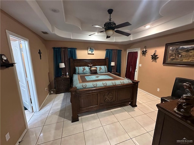 tiled bedroom with ceiling fan and a raised ceiling