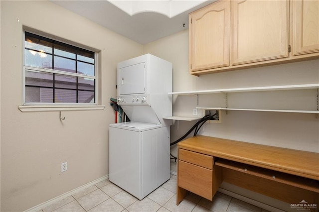 7207 Monroe St, Mission, TX 78572 - laundry area featuring stacked washing machine and dryer, cabinet space, baseboards, light tile patterned floors, and a desk