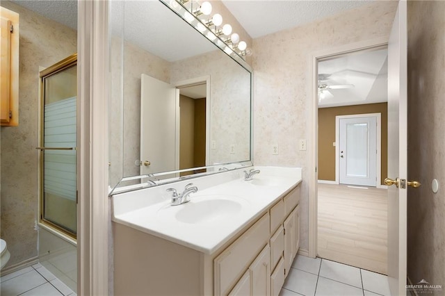 3703 N Glasscock Rd, Palmhurst, TX 78573 - bathroom featuring tile patterned flooring, double vanity, a textured ceiling, an enclosed shower, and a ceiling fan