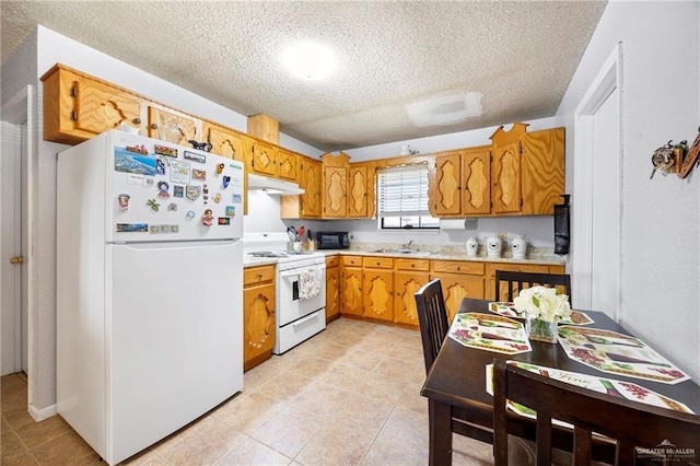 2309 W Chapin St, Edinburg, TX 78541 - kitchen with white appliances, a textured ceiling, light countertops, brown cabinetry, and light tile patterned floors