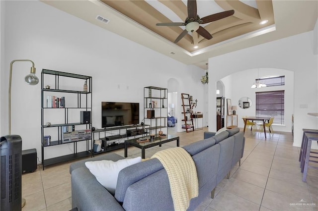 3604 Illeana St, Edinburg, TX 78539 - living room featuring arched walkways, light tile patterned flooring, ceiling fan, a towering ceiling, and a tray ceiling
