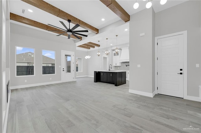 1809 W Hayes Ave, Alton, TX 78573 - unfurnished living room with ceiling fan, beamed ceiling, light wood-style flooring, baseboards, and recessed lighting