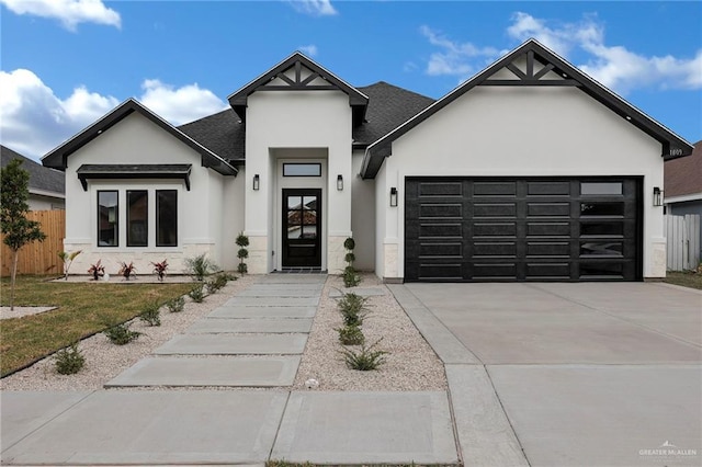 1809 W Hayes Ave, Alton, TX 78573 - view of front of home with stucco siding, an attached garage, driveway, a shingled roof, and stone siding
