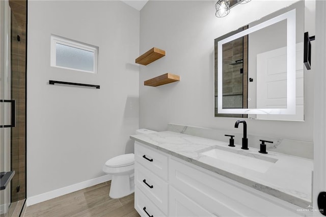 1809 W Hayes Ave, Alton, TX 78573 - bathroom featuring vanity, toilet, a stall shower, baseboards, and wood finished floors