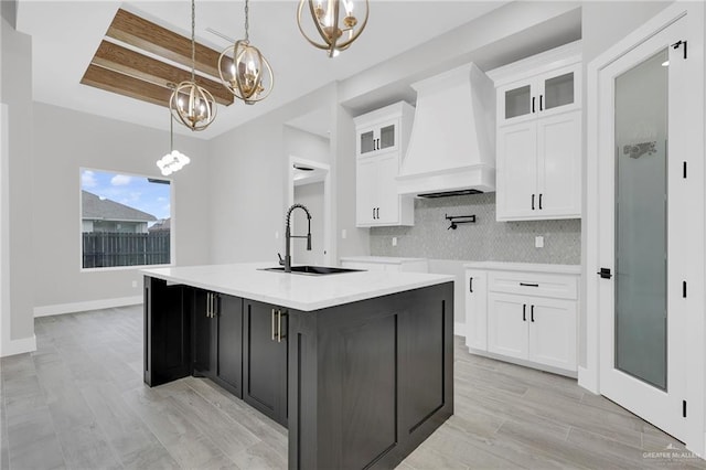 1809 W Hayes Ave, Alton, TX 78573 - kitchen featuring a sink, a chandelier, premium range hood, white cabinetry, and a center island with sink