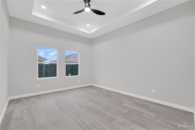 1809 W Hayes Ave, Alton, TX 78573 - empty room with light wood-type flooring, ceiling fan, baseboards, recessed lighting, and a raised ceiling