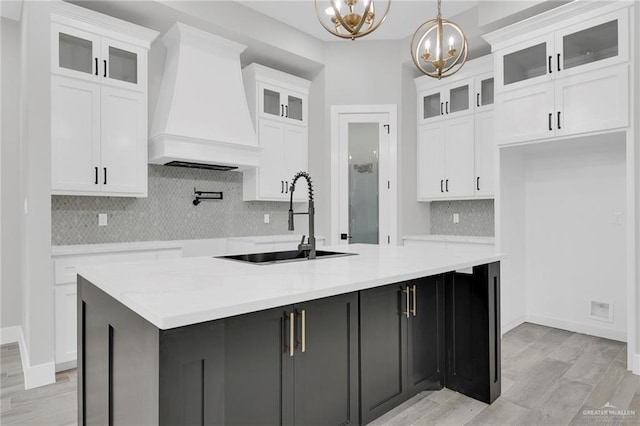 1809 W Hayes Ave, Alton, TX 78573 - kitchen featuring custom exhaust hood, a sink, a chandelier, a large island with sink, and white cabinets