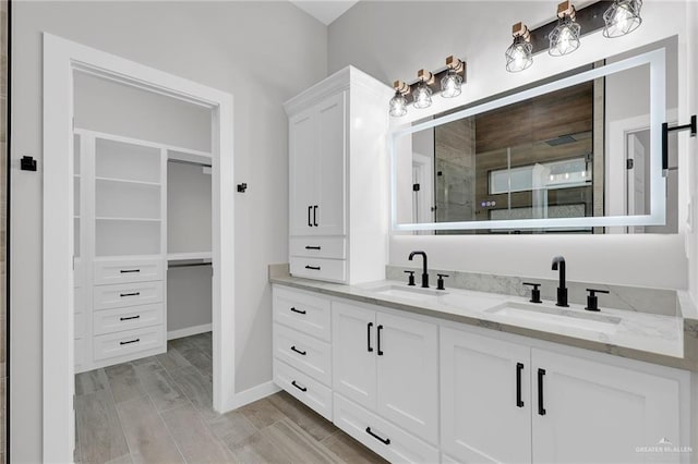 1809 W Hayes Ave, Alton, TX 78573 - full bathroom with double vanity, a shower stall, baseboards, and a spacious closet