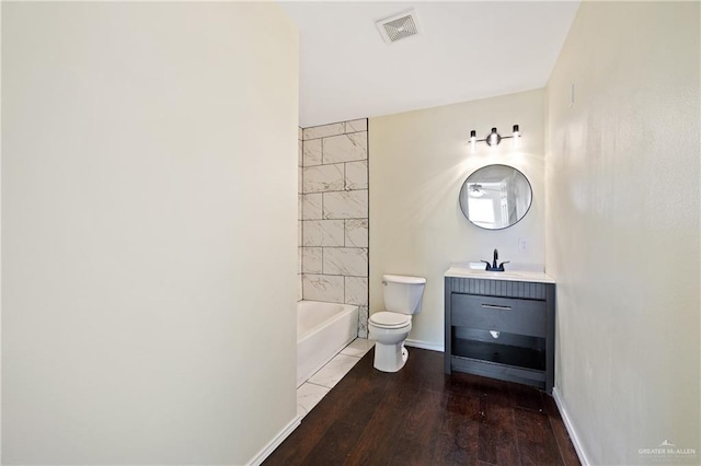 full bathroom with vanity, toilet, tiled shower / bath combo, and hardwood / wood-style floors