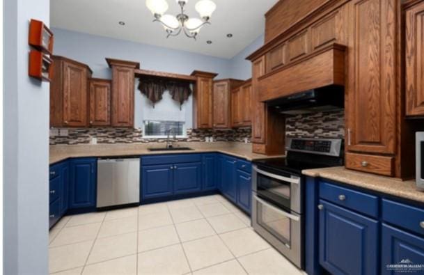 kitchen featuring tasteful backsplash, stainless steel appliances, exhaust hood, sink, and a chandelier