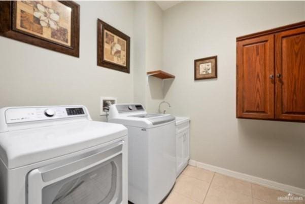 laundry area with cabinets, light tile patterned floors, and washer and dryer