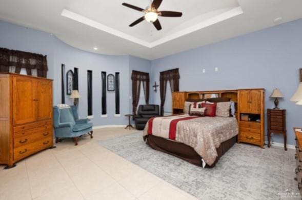 bedroom featuring ceiling fan and a tray ceiling