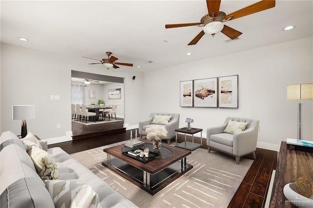 living area featuring baseboards, wood finished floors, and recessed lighting