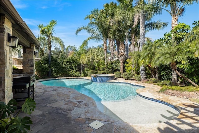 view of pool with a patio area and a pool with connected hot tub