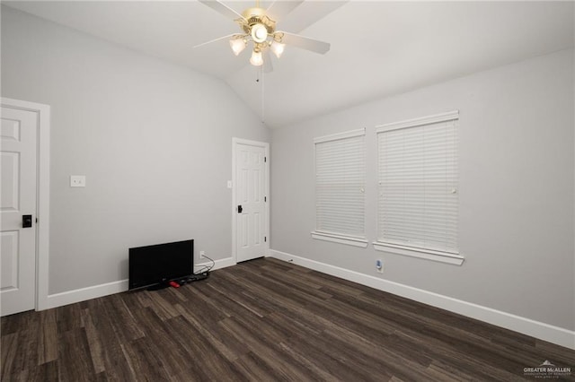 empty room with lofted ceiling, dark wood-style flooring, ceiling fan, and baseboards