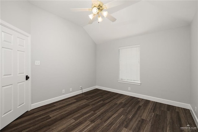 spare room featuring a ceiling fan, dark wood-style flooring, vaulted ceiling, and baseboards