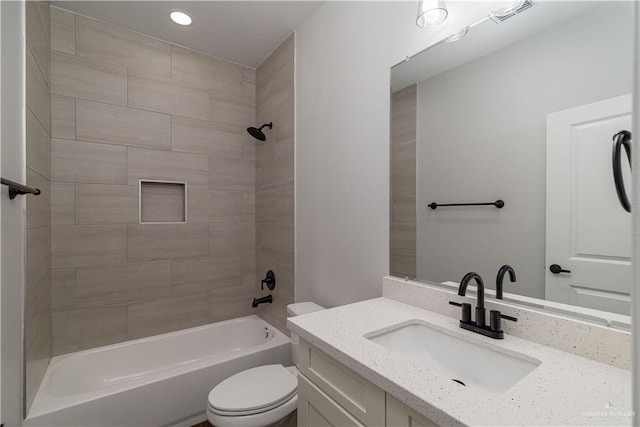 full bathroom featuring vanity, toilet, and tiled shower / bath