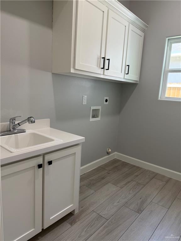 1203 Moses Dr, San Juan, TX 78589 - clothes washing area featuring hookup for a washing machine, a sink, light wood-style flooring, cabinet space, and electric dryer hookup
