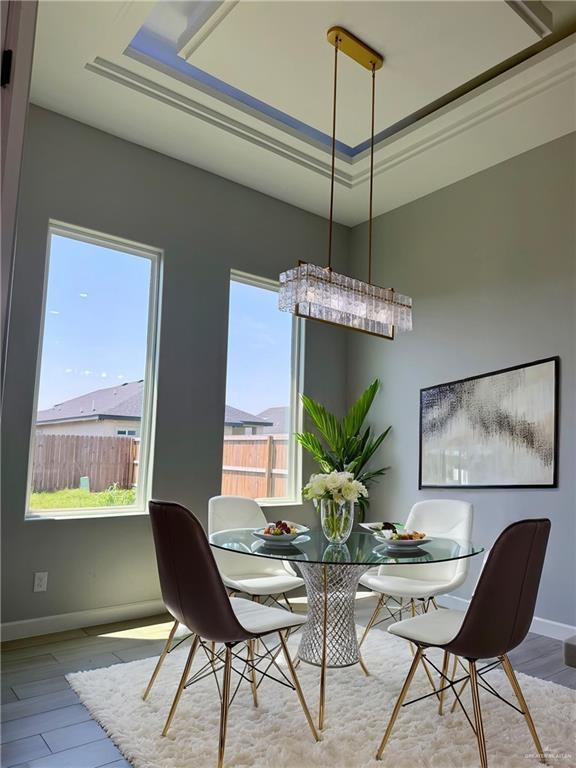 1203 Moses Dr, San Juan, TX 78589 - dining room with a raised ceiling, baseboards, and wood finished floors