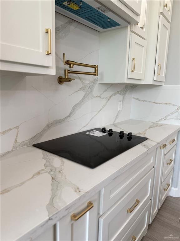 1203 Moses Dr, San Juan, TX 78589 - kitchen featuring black electric cooktop, white cabinets, decorative backsplash, and range hood