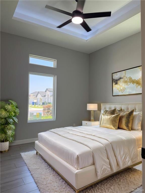 1203 Moses Dr, San Juan, TX 78589 - bedroom featuring baseboards, wood finished floors, ceiling fan, and a raised ceiling