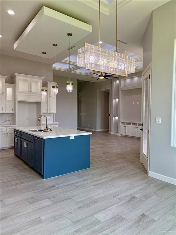 1203 Moses Dr, San Juan, TX 78589 - kitchen featuring a sink, a ceiling fan, open floor plan, a kitchen island with sink, and white cabinets