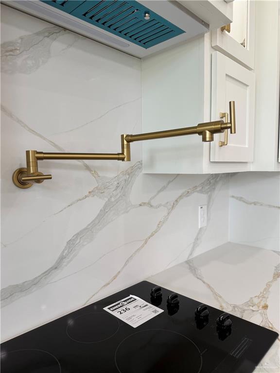1203 Moses Dr, San Juan, TX 78589 - details featuring white cabinetry, light stone counters, ventilation hood, and range