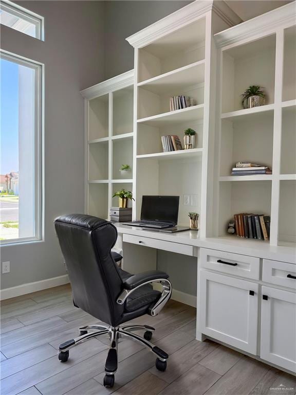 1203 Moses Dr, San Juan, TX 78589 - home office with built in study area, baseboards, and light wood-style floors