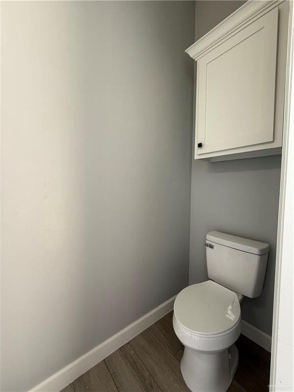 1203 Moses Dr, San Juan, TX 78589 - bathroom with toilet, baseboards, and wood finished floors