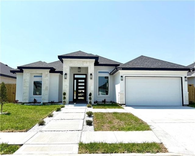 1203 Moses Dr, San Juan, TX 78589 - prairie-style house with driveway, an attached garage, a shingled roof, and stucco siding