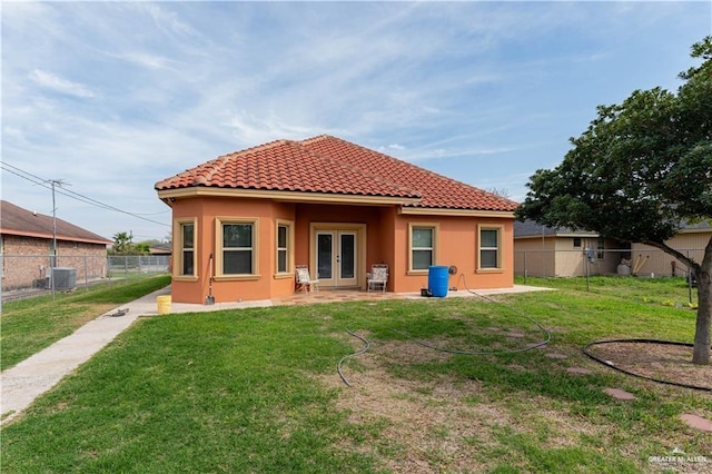 back of property featuring french doors, a lawn, a fenced backyard, and stucco siding