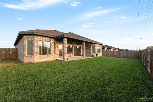 back of house featuring a lawn and a patio area