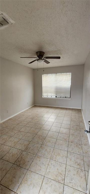 tiled spare room with a textured ceiling and ceiling fan