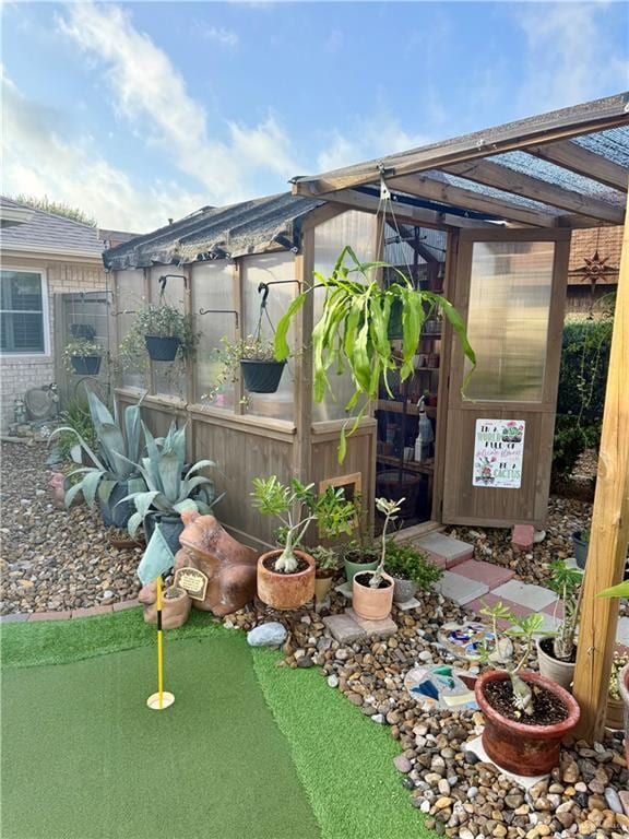 1813 Tyler St, Mission, TX 78572 - view of yard with a greenhouse, a putting green, and an outbuilding