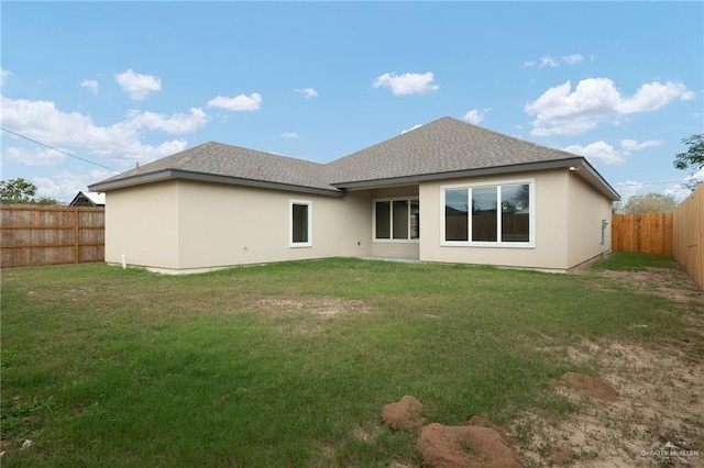 rear view of property featuring a lawn