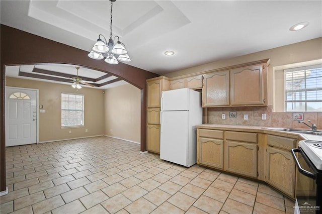 kitchen featuring a raised ceiling, sink, electric range, decorative light fixtures, and white fridge