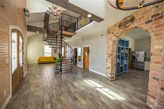 foyer entrance with a notable chandelier, dark hardwood / wood-style flooring, and high vaulted ceiling