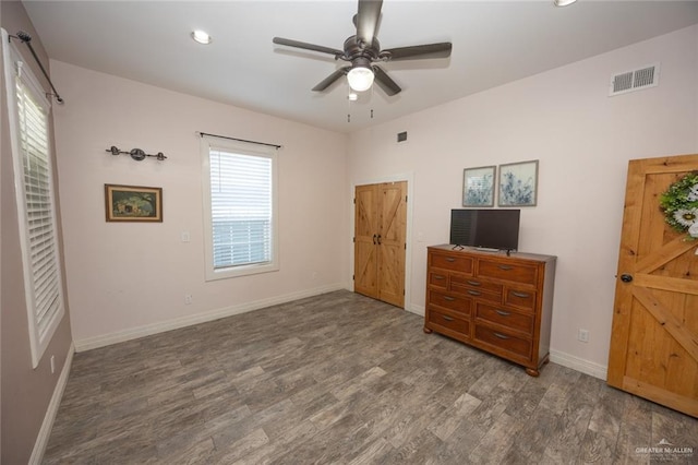 unfurnished bedroom featuring ceiling fan and dark hardwood / wood-style flooring