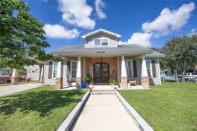 view of front of property featuring covered porch, french doors, and a front yard