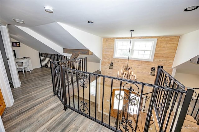 hallway featuring hardwood / wood-style flooring and an inviting chandelier