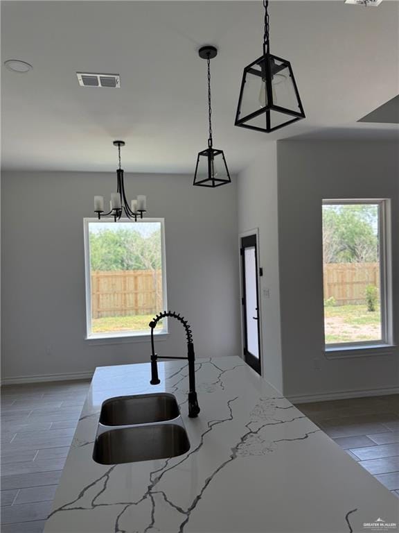 3614 Tecate St, Edinburg, TX 78542 - kitchen with light stone countertops, hanging light fixtures, and a chandelier