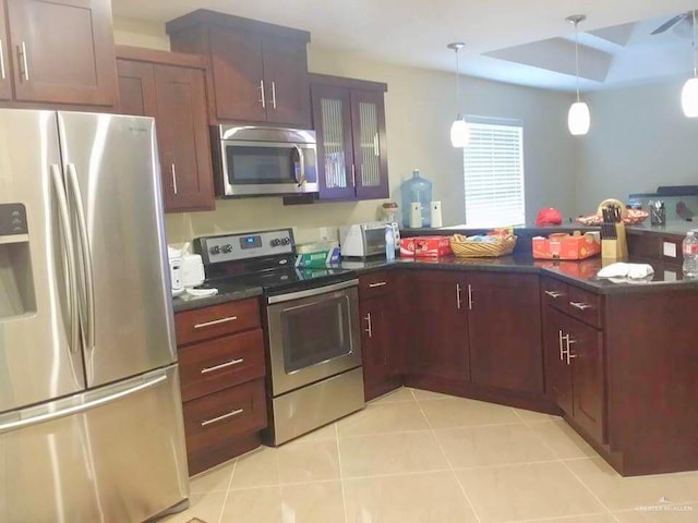 kitchen with kitchen peninsula, light tile patterned floors, hanging light fixtures, and appliances with stainless steel finishes