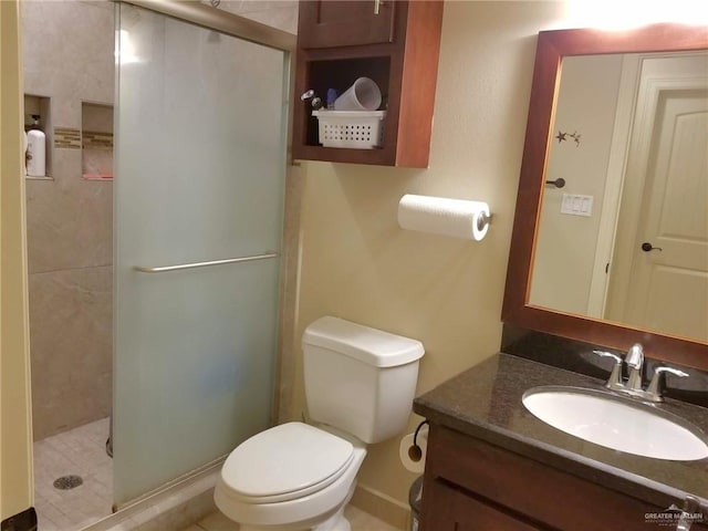 bathroom featuring an enclosed shower, vanity, toilet, and tile patterned floors