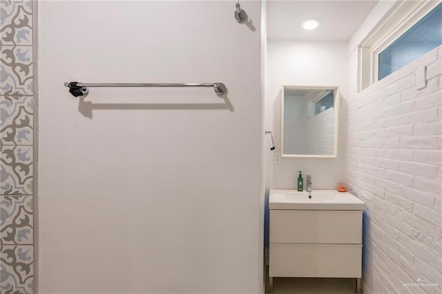 bathroom with vanity and brick wall