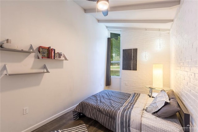 bedroom featuring baseboards, lofted ceiling with beams, brick wall, ceiling fan, and wood finished floors