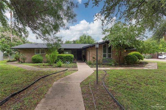 view of front facade with a front yard and brick siding