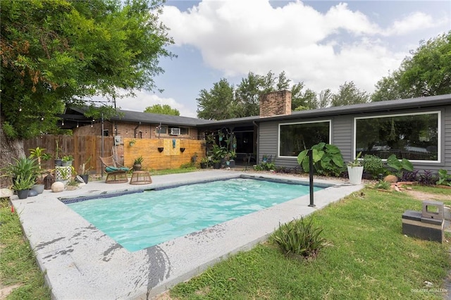 view of pool featuring a yard, a fenced in pool, a patio area, and fence